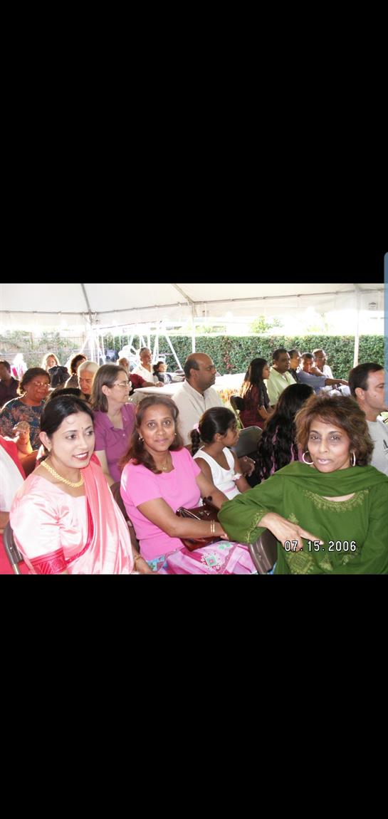 People enjoy a cultural celebration together under a tent, dressed in colorful traditional attire.