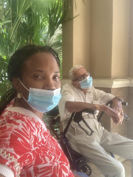 Two masked individuals relax together in a garden, enjoying each other's company.