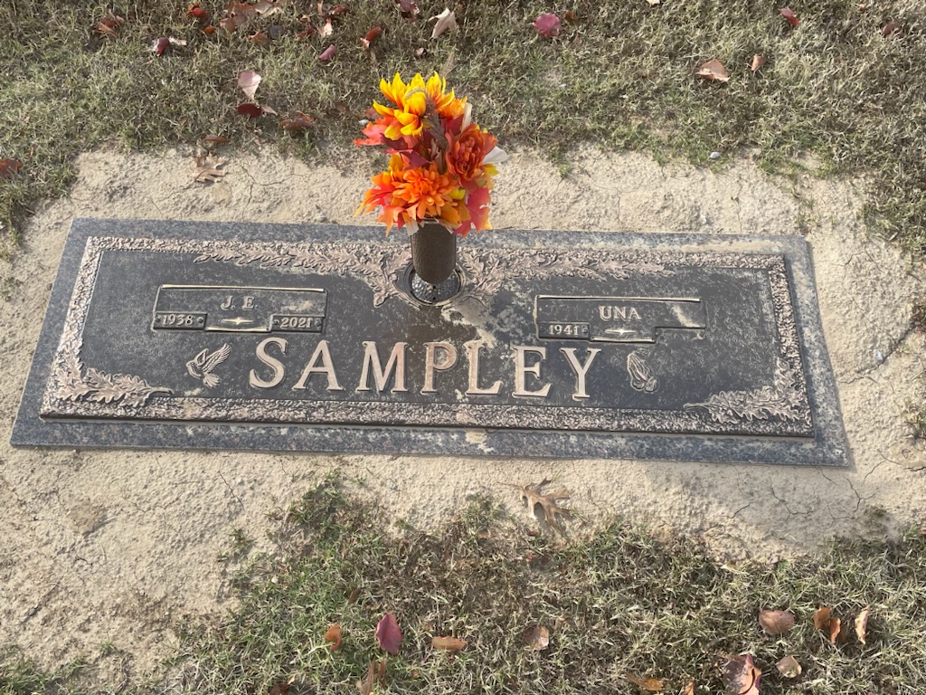 A grave stone with flowers in it