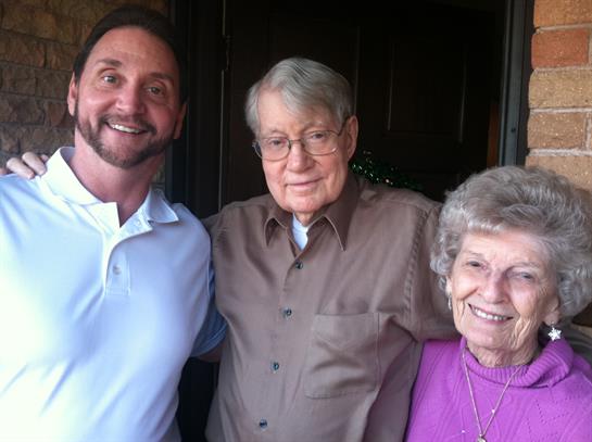 Three family members pose together with smiles outside during a joyful family reunion gathering.