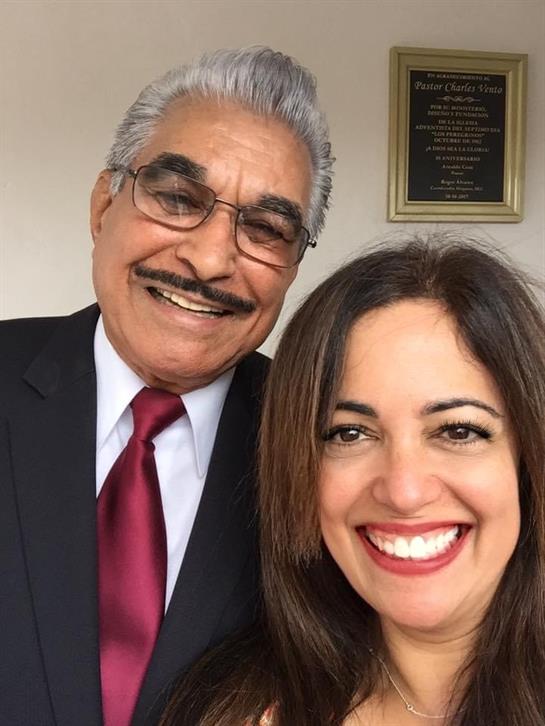 Two individuals enjoy a joyful moment together at a formal event, smiling brightly.