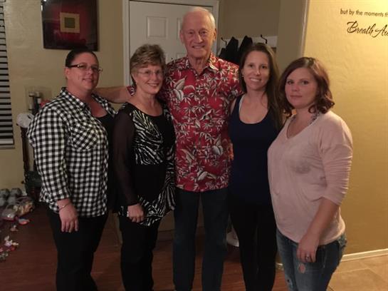 Five family members pose together in a warm indoor environment, radiating joy and connection.