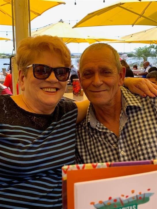 Friends sitting together under umbrellas, sharing laughs and enjoying a warm, sunny day.