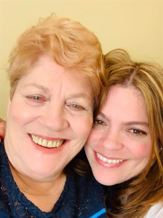 Two women embrace and smile, capturing the joy and connection of their friendship.