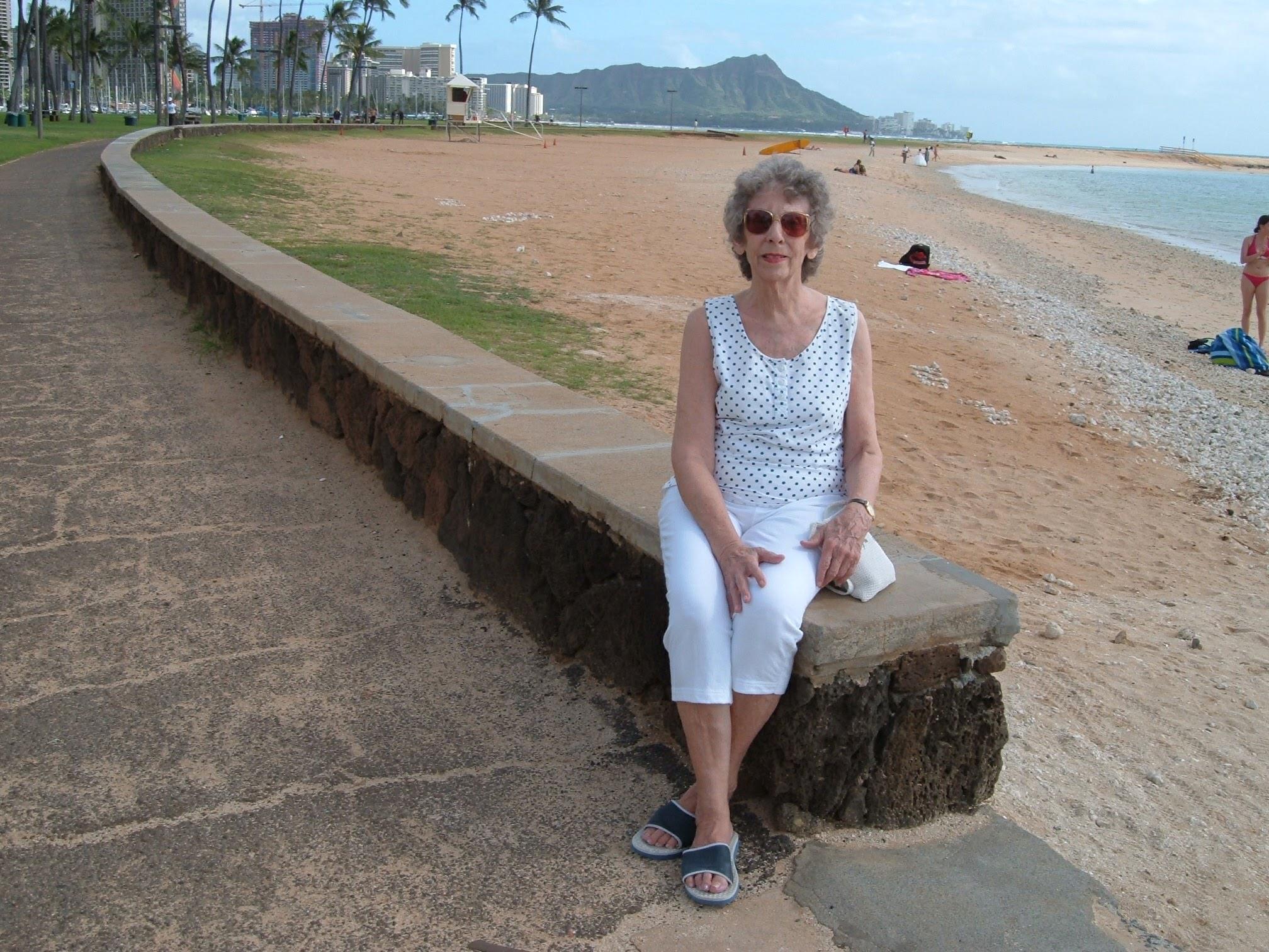 A woman sitting on a rock on a beach