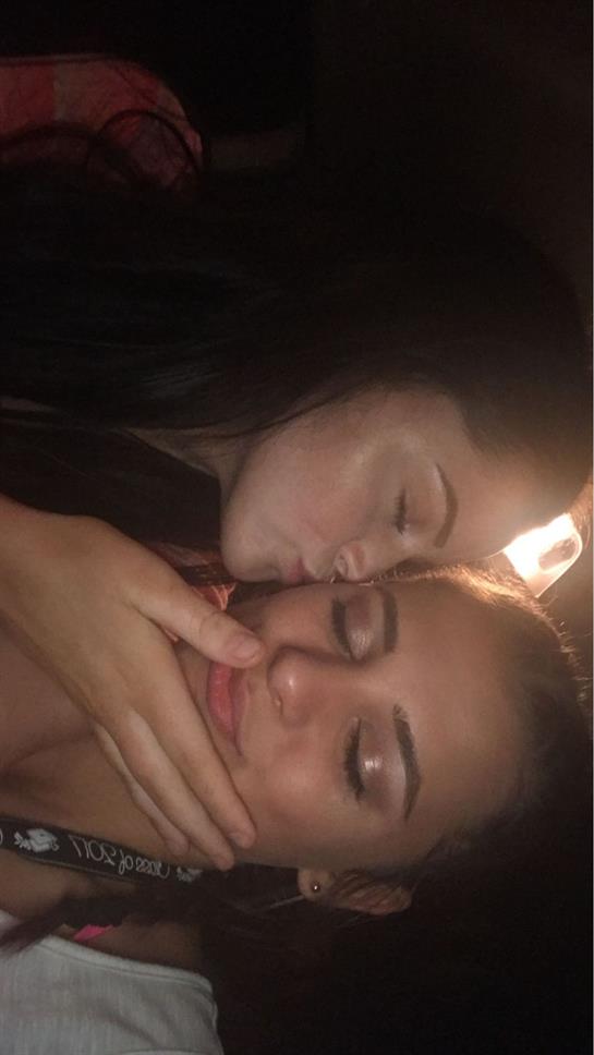 Two friends lean in close, sharing a gentle kiss, creating a warm and intimate atmosphere together.