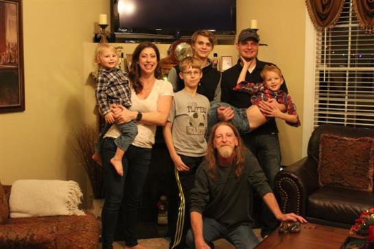 Family members of various ages gather in a lively indoor atmosphere, sharing joy and laughter.