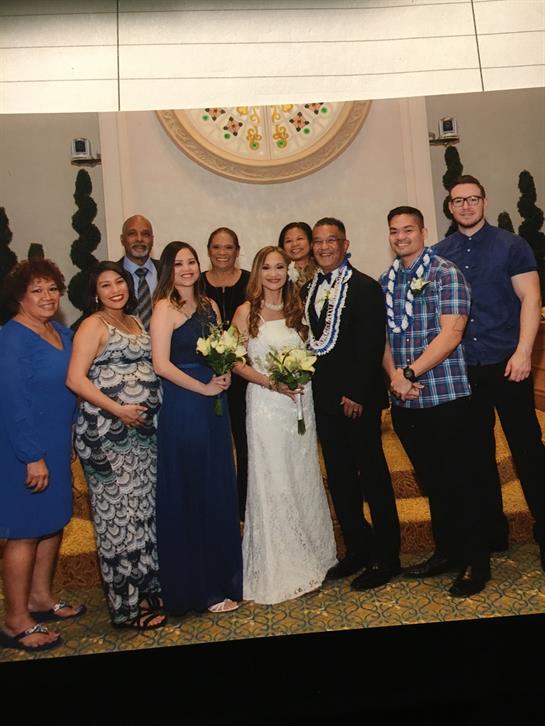 Group of people gathers together in formal attire at a wedding, celebrating love and unity.