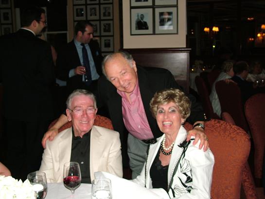 Three friends share smiles and laughter at a cozy restaurant during a joyful gathering.