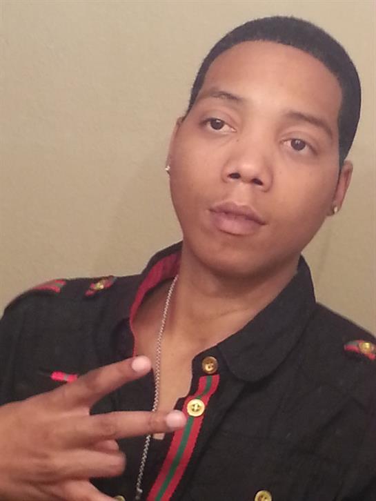 Portrait of an individual making a peace sign with their hand, dressed in a stylish outfit.