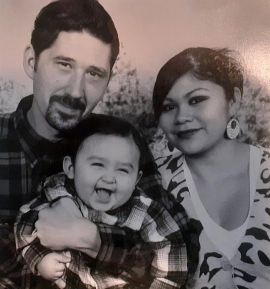 A joyful family enjoys quality outdoor time, with a child playfully sticking out their tongue.