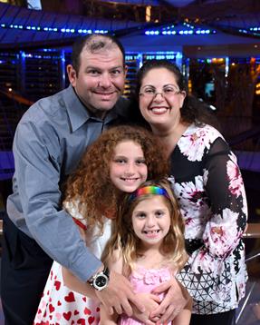A joyful family gathers close, sharing happiness during a lively indoor gathering.