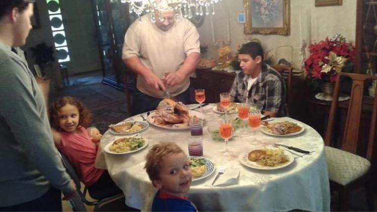 Families enjoy a meal together at a beautifully set dining table with festive decorations.