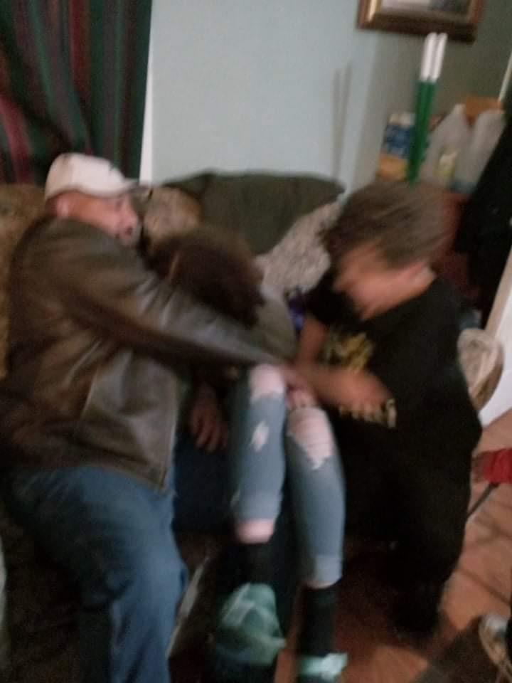 Three friends lounge on a couch, laughing and playing together.