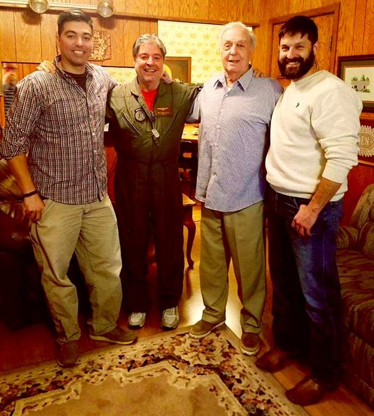 Four friends celebrate their long-awaited reunion in a cozy, decorated living room.