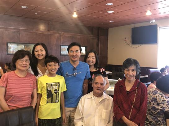 A lively group poses happily in a restaurant, capturing a moment of family bonding and joy.