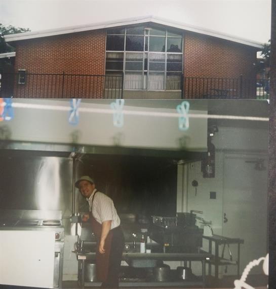 A chef is preparing food in a well-equipped kitchen outside a rustic building during the day.