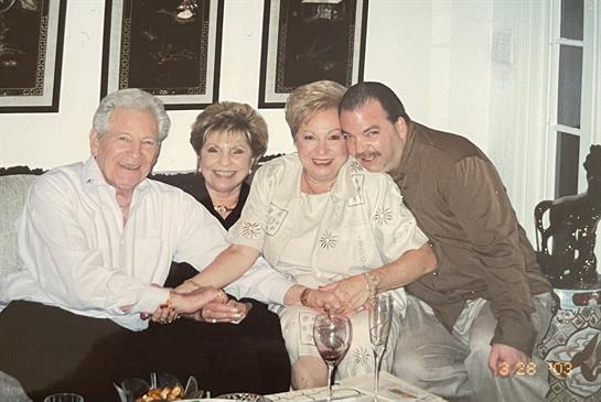 Four friends gather around a table, sharing laughter and stories in a warm atmosphere.