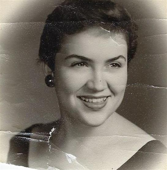 A young woman with a joyful expression poses in a formal dress, capturing a timeless moment.