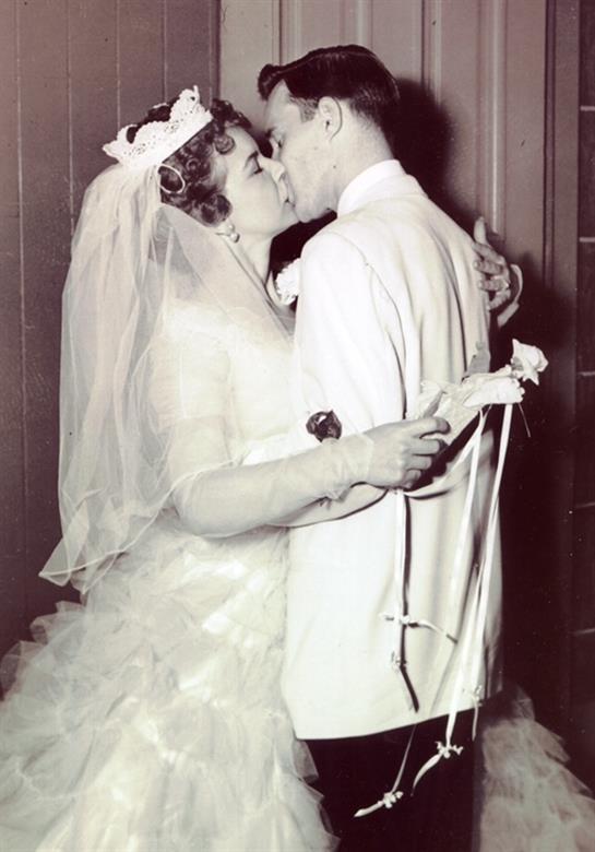 Newlyweds embrace and kiss joyfully, surrounded by an atmosphere of celebration and love.