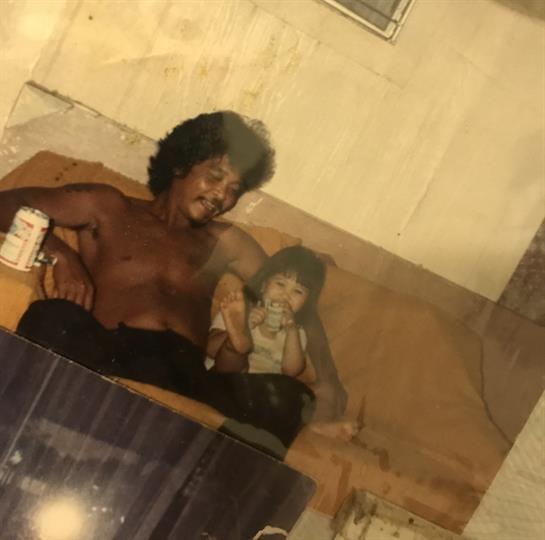 A man and a child share a relaxed moment indoors, enjoying each other's company.