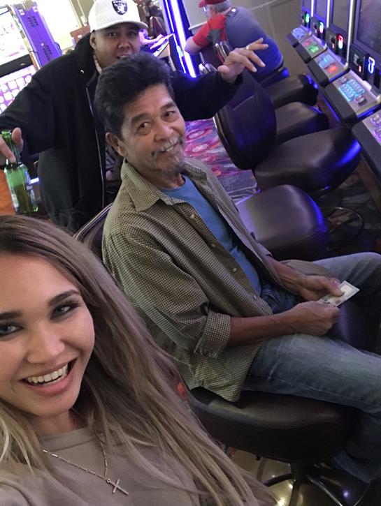 Couple smiling and having fun at a vibrant casino filled with slot machines and excitement.