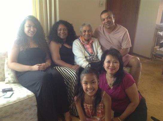 A joyful family gathering featuring multiple generations enjoying each other's company at home.