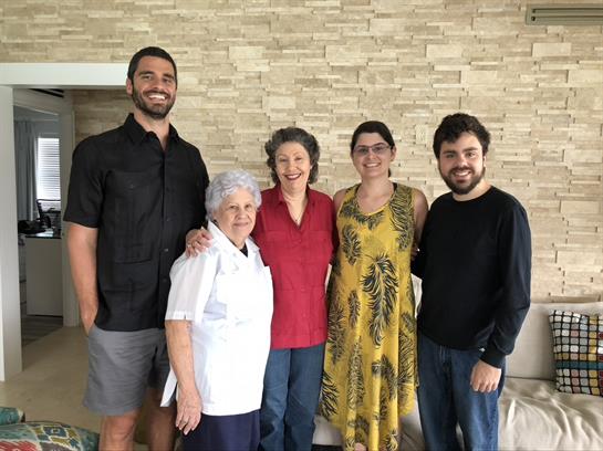 Five family members celebrate together in a warm and inviting home environment.