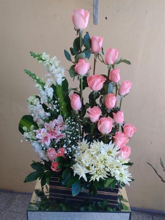 Vibrant floral arrangement with pink roses, white blooms, and greenery highlights nature's beauty.