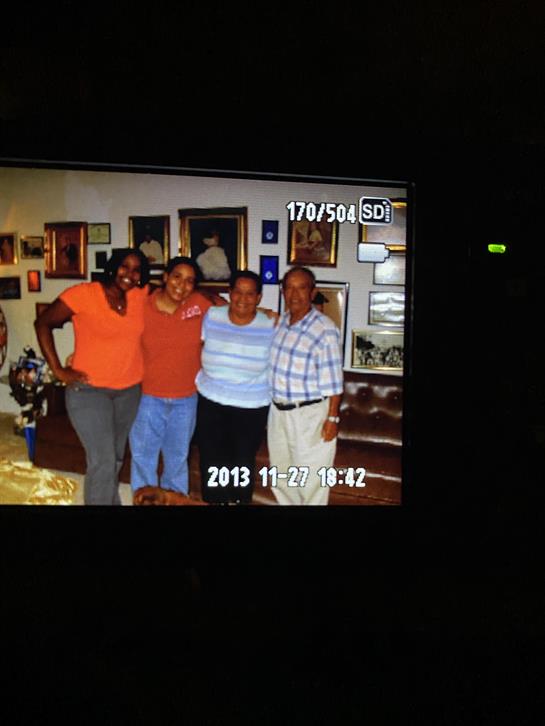 Four friends smile and pose in a cozy indoor environment filled with artwork and decor.