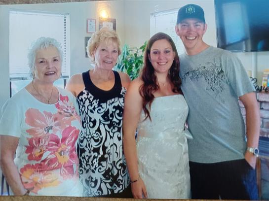 Four smiling family members celebrate a wedding in a warm, inviting atmosphere.