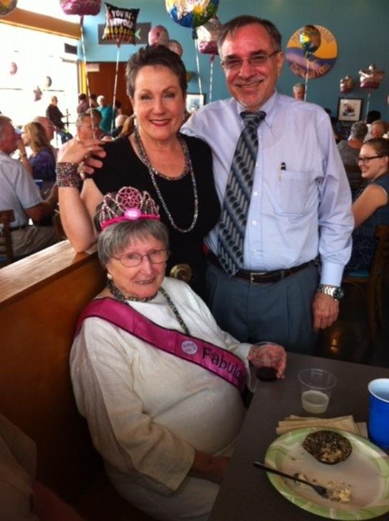 Guests gather in a restaurant to celebrate a milestone birthday with smiles and joy.