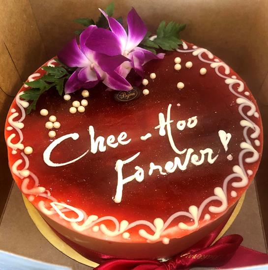 A beautifully decorated cake featuring flowers, a heartfelt message, and intricate designs.