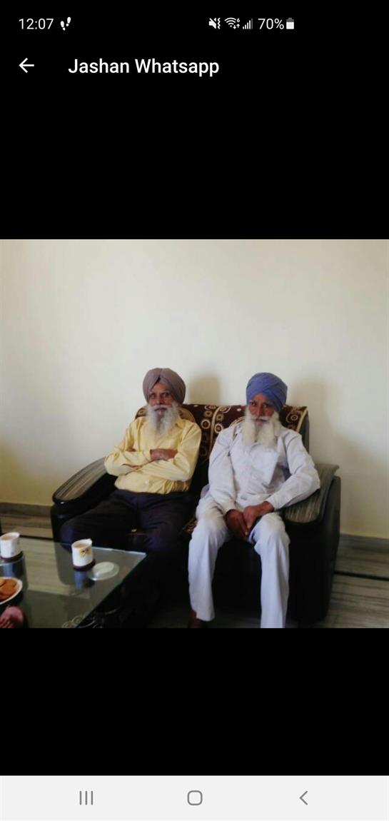 Elderly men with beards enjoy each other's company on a comfortable sofa in a relaxed atmosphere.
