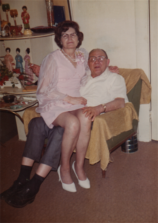 A couple smiles in a cozy vintage living space, reflecting warmth and companionship.