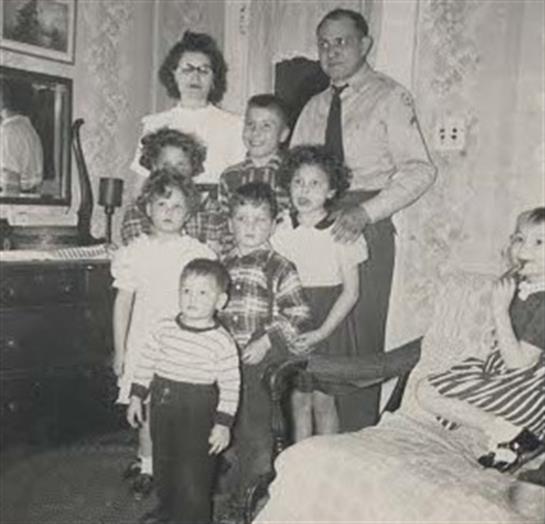 A cozy living room hosts a family in classic attire, joyfully gathered together.