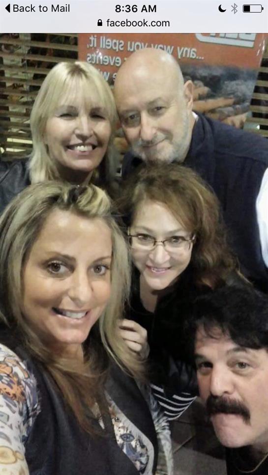 Five friends smile and pose together in a cheerful atmosphere during their gathering.