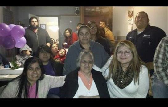 A group of family members enjoys each other's company in a cozy indoor space, smiling and engaging.