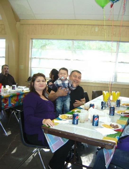 A cheerful family enjoys lunch together in a well-lit dining room filled with food and drinks.