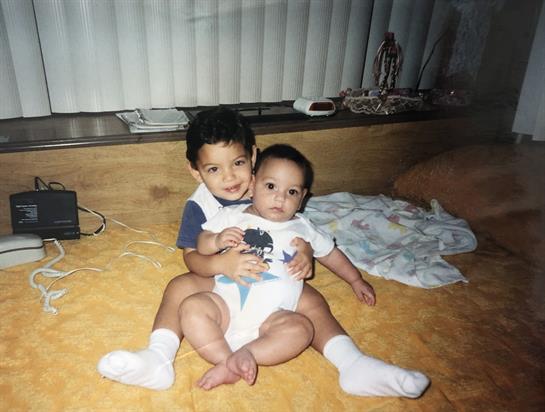 Two brothers share a joyful moment on a cozy floor, embodying sibling love and connection.