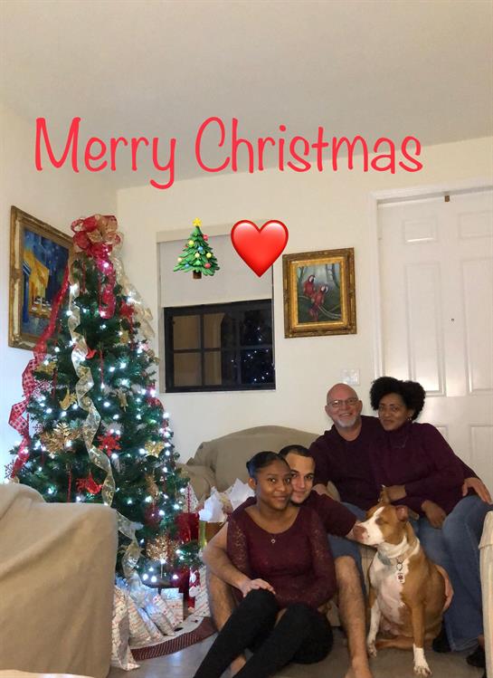 A joyful family is seated near a festive Christmas tree, creating lasting holiday memories.