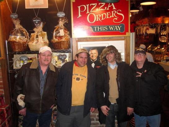 Four friends enjoy a casual moment together at a lively pizzeria filled with charm.