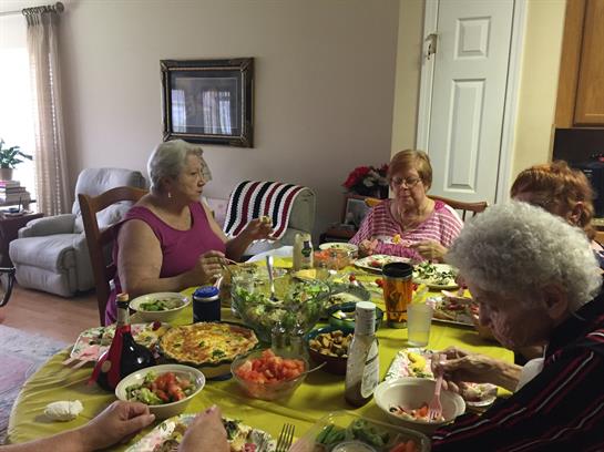 Group of women enjoy a hearty meal together, featuring colorful dishes and vibrant conversation.