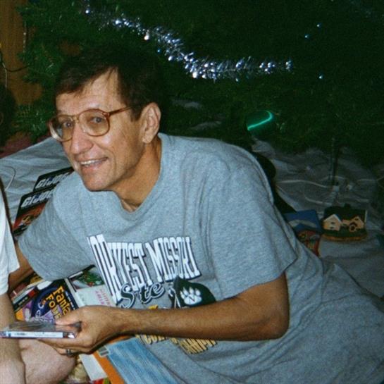 A man engages with a child in a cozy indoor setting filled with warm lights and casual atmosphere.