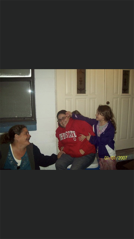 Three friends enjoy a lighthearted moment indoors, smiling and interacting playfully.