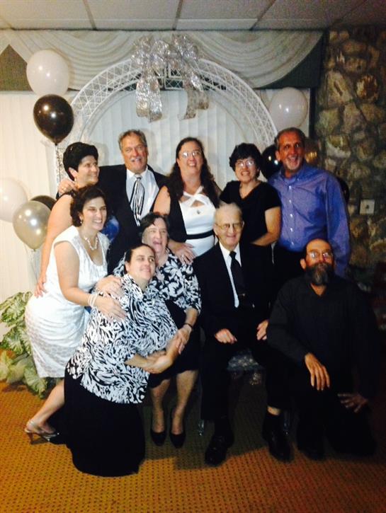 Group of family and friends gathered together celebrating an event with smiles and laughter.