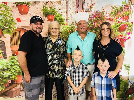 Family poses together in a vibrant outdoor location, showcasing smiles and a joyful atmosphere.