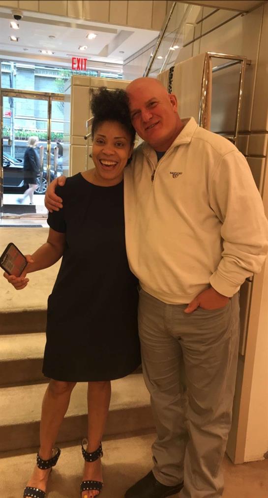 Two friends pose joyfully together in a lively cafe, enjoying their time in the city.