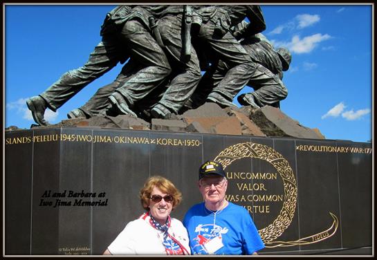 Two veterans stand in front of the Iwo Jima Memorial, showcasing their pride and camaraderie.