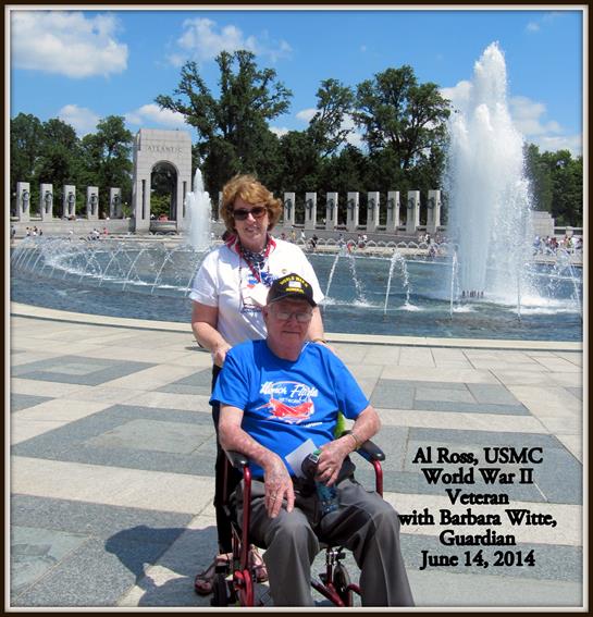 A World War II veteran enjoys a moment at the memorial with his guardian on a sunny day.